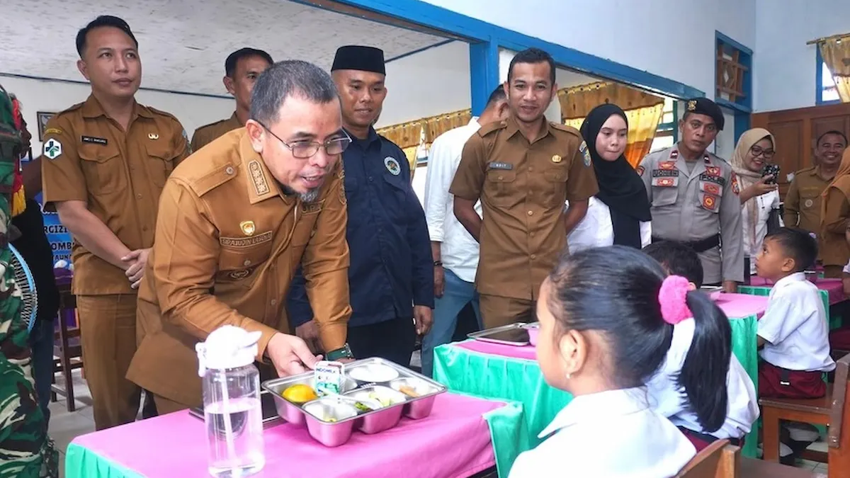 Bupati Boltara Sirajudin Lasena menyerahkan makanan bergizi kepada siswa Program MBG sulutviral.info