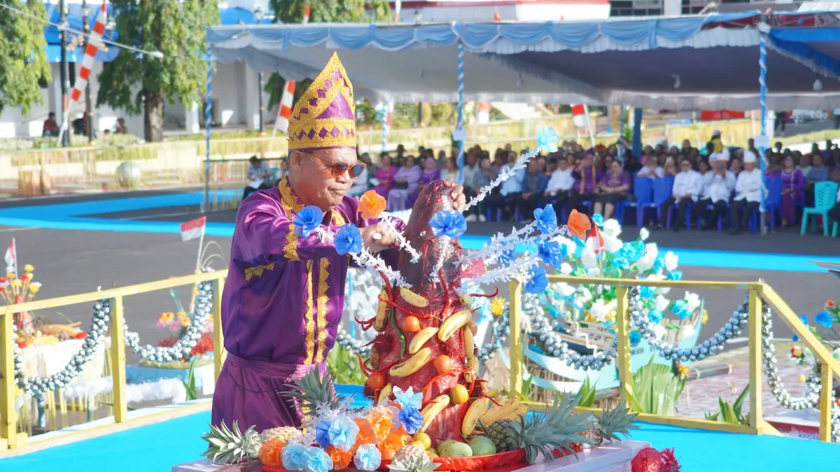 Prosesi pemotongan kue adat Tamo sebagai simbol syukur dalam Upacara Adat Tulude Kota Bitung 2026 sulutviral.info
