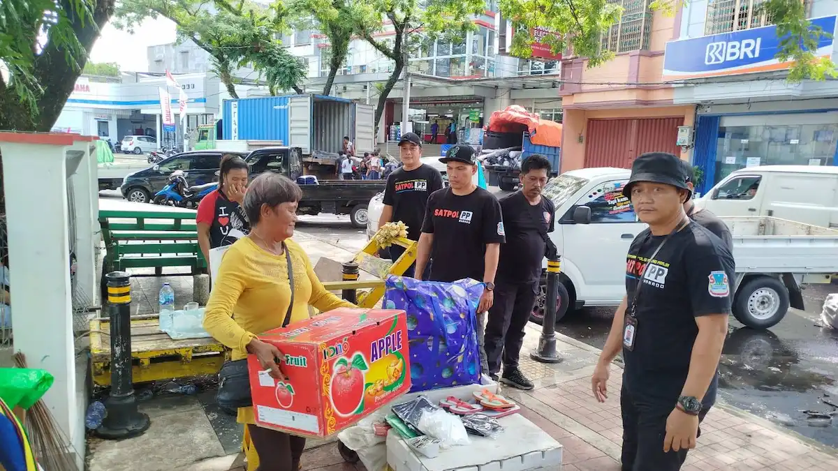 Petugas membantu penataan lapak pedagang kaki lima agar tidak mengganggu fungsi jalan dan trotoar di Kota Manado sulutviral.info